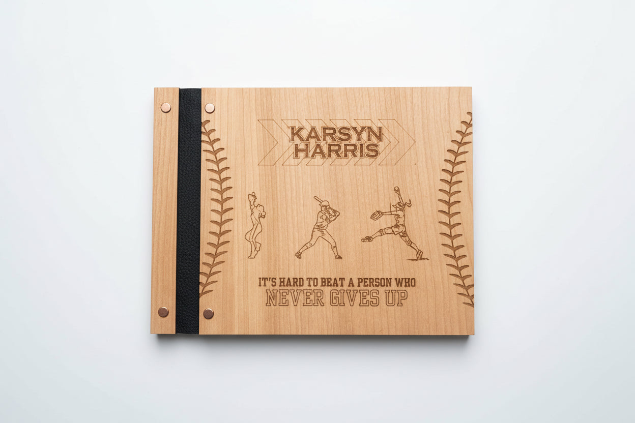 Wooden notebook with engraved text and illustrations on a wooden surface with a plant in the background