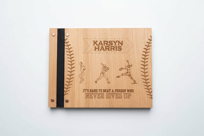 Wooden notebook with engraved text and illustrations on a wooden surface with a plant in the background