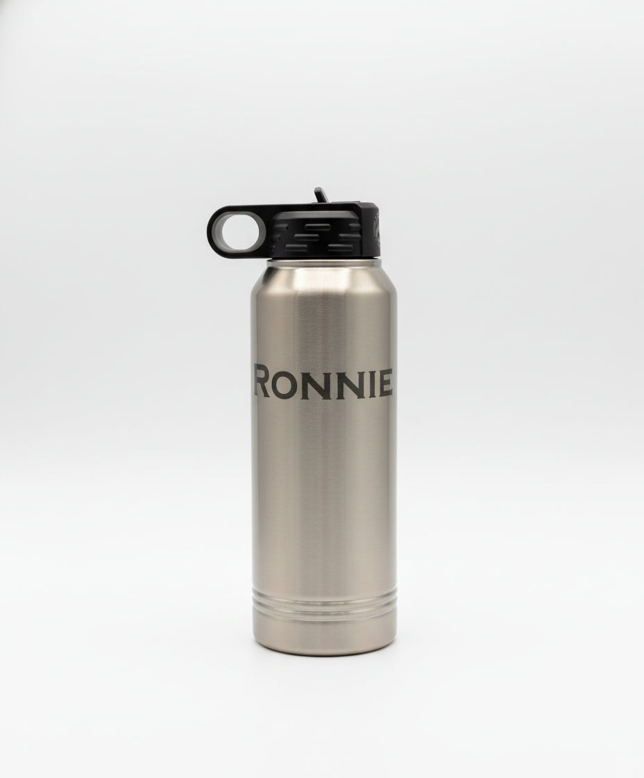 Silver water bottle with 'RONNIE' branding on a wooden surface with a plant in the background.